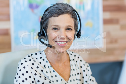 Smiling travel agent sitting at her desk