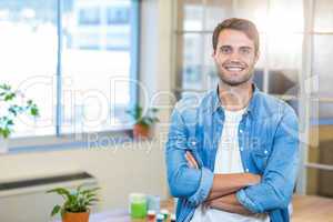 Casual businessman smiling at camera with arms crossed