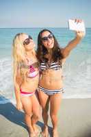 two friends in swimsuits taking a selfie