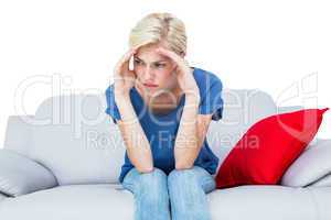 Thoughtful blonde woman sitting on the couch