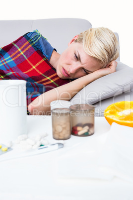 Sick blonde woman lying on the couch