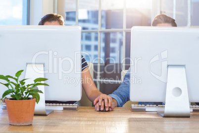 Couple working on computers and holding hands