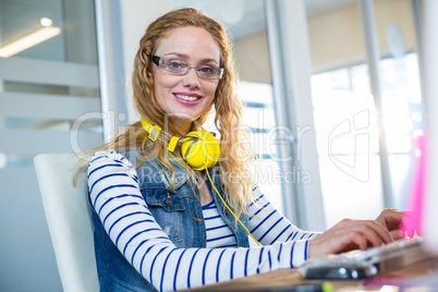 Smiling designer typing on keyboard