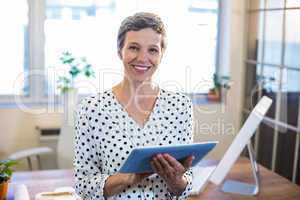 Smiling woman holding tablet and looking at camera