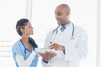 Smiling doctors reading files