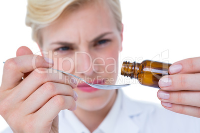 Doctor pouring medicine in spoon