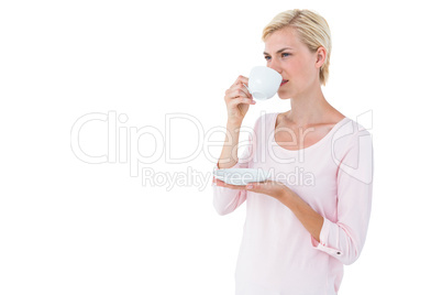 Attractive blonde woman drinking hot beverage
