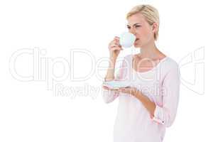 Attractive blonde woman drinking hot beverage