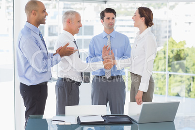 Business team congratulating their colleague