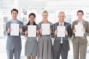 Business colleagues holding sheets of paper together