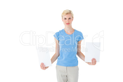Stern blonde woman holding sheets of paper