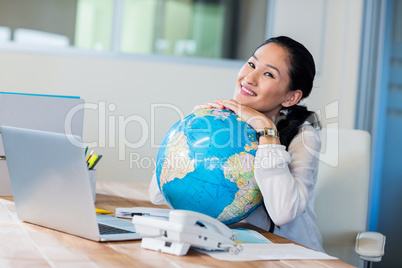 Pretty businesswoman holding globe