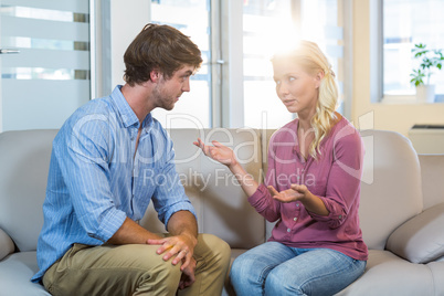 Unsmiling couple talking to each other