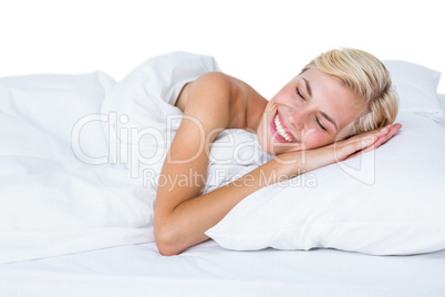 Smiling blonde woman napping in her bed