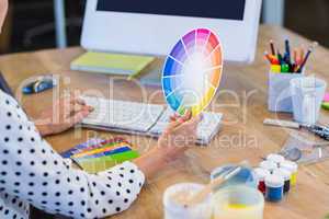 Casual businesswoman working with computer and colour chart