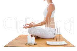 Fit woman meditating on bamboo mat