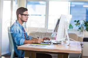 Casual businessman using digitizer at his desk