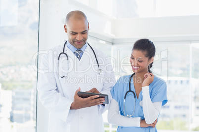 Smiling doctors working with tablet together