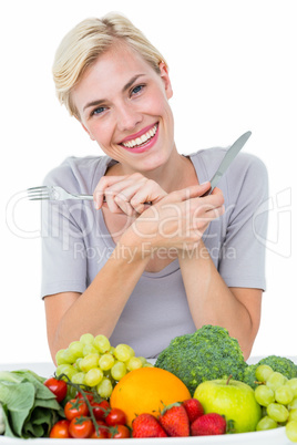 Happy blonde woman sitting above healthy food