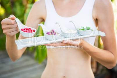 Fit woman holding plate with herbal medicine