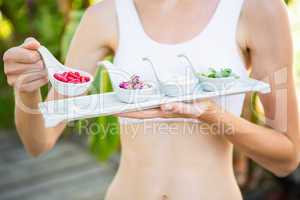 Fit woman holding plate with herbal medicine