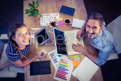 Happy creative workers sharing desk