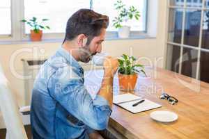 Man sitting at his desk and drinking coffee