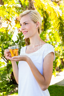 Attractive blonde woman holding glass of tea