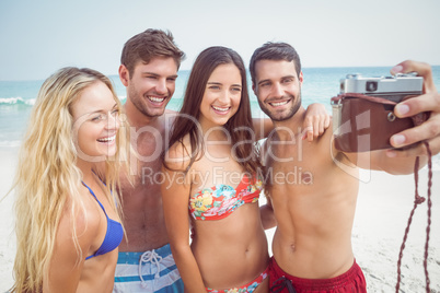 group of friends in swimsuits taking a selfie