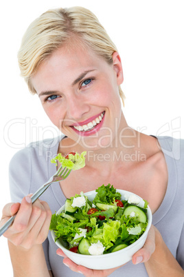 Happy blonde woman holding bowl of salad