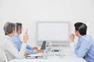 Business team looking at white screen