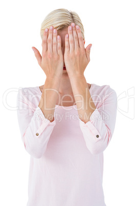 Blonde woman covering her face