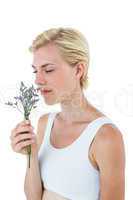 Gorgeous blonde woman smelling flowers
