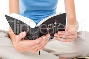 Woman sitting on the floor and reading bible