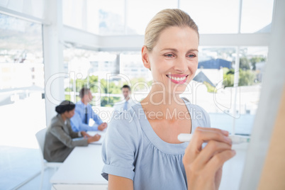 Businesswoman writing brainstorming ideas on board