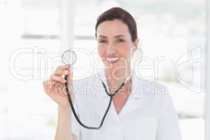 Smiling doctor looking at camera and showing stethoscope