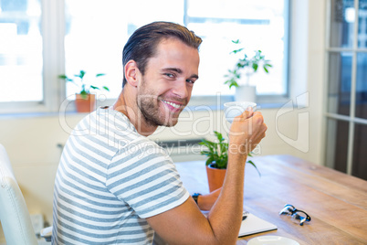 Man sitting at his desk and drinking coffee