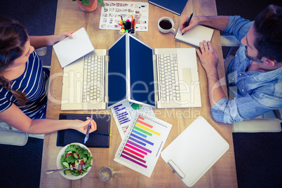 Happy creative workers sharing desk