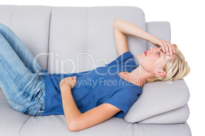 Attractive blonde woman having headache on the couch