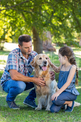 Father and daughter with their pet dog in the park