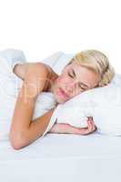 Smiling blonde woman napping in her bed