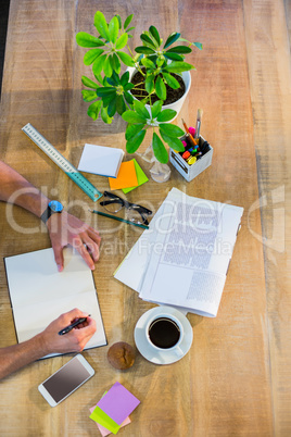 Businessman writing in notepad