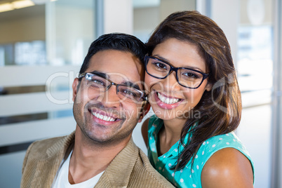 Happy couple embracing and looking at the camera