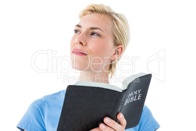 Pretty blonde woman reading bible