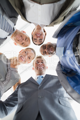 Business colleagues standing in circle and looking at camera