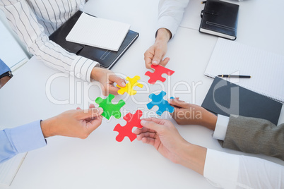 Business colleagues holding piece of puzzle