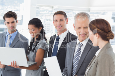 Business colleagues showing their multimedia devices to each oth