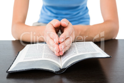 Woman praying while reading bible