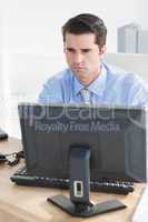 Concentrated businessman using his computer