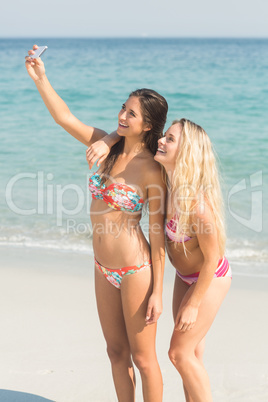 two friends in swimsuits taking a selfie